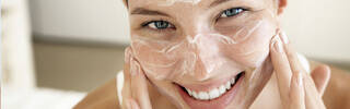 WOMAN EXFOLIATING HER FACE