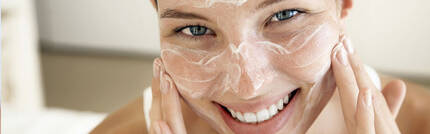 WOMAN EXFOLIATING HER FACE