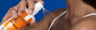 Close up of Anthelios Spray Sunscreen being applied to skin